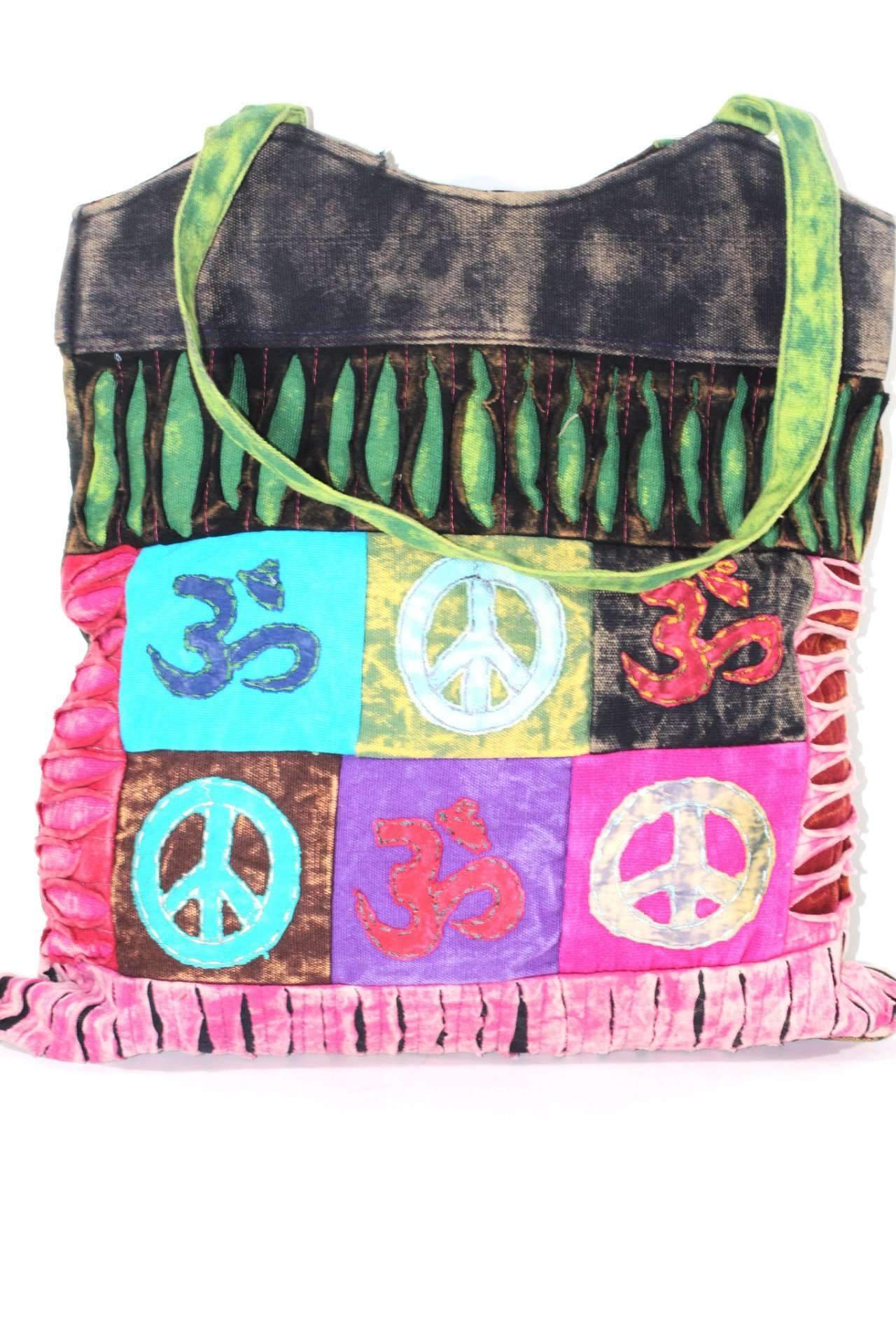 The Peace & Om Patchwork Jhola Carry Bag, featuring green handles, presents spiritual symbols like peace and Om in multicolored embroidered squares through its vibrant handmade design.
