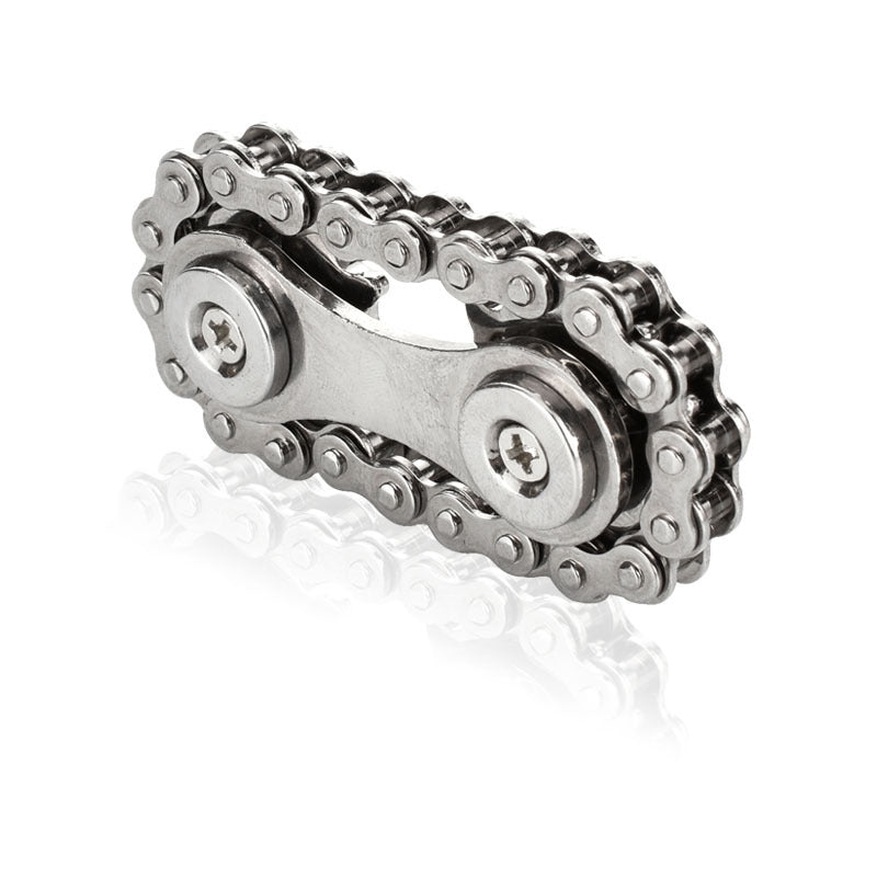 A Bike Chain Gear Spinner with two rivets lies on a glossy white surface, evoking the image of a sleek gear fidget spinner crafted for contemporary stress relief.