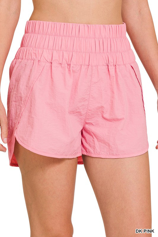 Rear view of a person wearing bright pink Windbreaker Smocked Waistband Running Shorts.