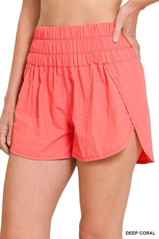 Rear view of a person wearing bright pink Windbreaker Smocked Waistband Running Shorts.