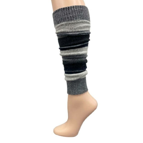 The Girl's Stripe Lambswool Knee Hi Leg Warmers, adorned with colorful stripes in blue, pink, purple, and white, are showcased on a mannequin leg as cozy essentials for the cold season.