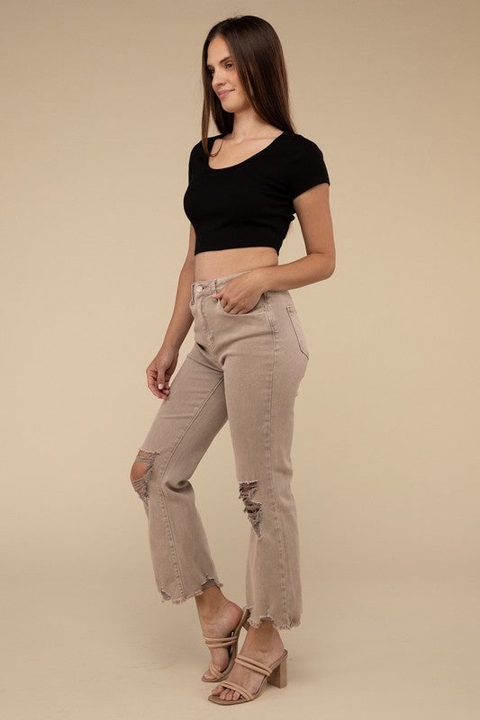 Person wearing acid washed high waist distressed straight pants and beige sandals against a neutral background.