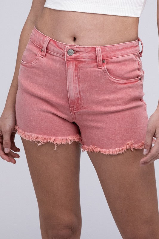 Close-up of a person wearing Acid Washed Frayed Cutoff Hem Shorts and a black top with lace-up details on the side.