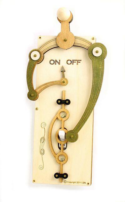 The Single Toggle Switch Plate 8001C Natural Wood & Green is a decorative cover with an artistic design featuring levers and gears in natural wood and green tones, labeled "ON OFF." It adds a unique touch to any room.