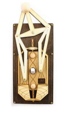 Wall art featuring wood and metal geometric shapes, a central pulley system, and the Light Rig Switch Plate 8004D Brown.