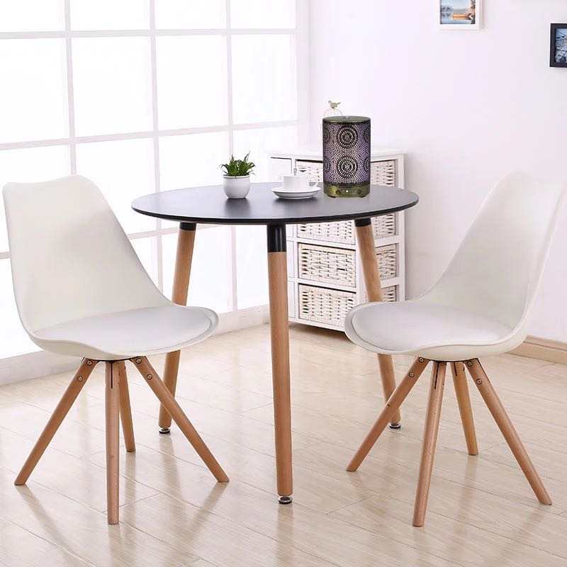 A chic Color Changing Aromatherapy Oil Diffuser with a floral motif rests on a wooden table, softly releasing mist enhanced with essential oils. In the background, a vase displays vibrant flowers, crafting an ideal aromatherapy atmosphere.