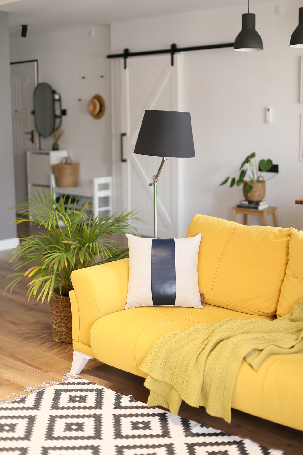 In a well-lit room, a black wire chair is tastefully adorned with a Boho Handcrafted Decorative Single Throw Pillow Cover in beige and brown, featuring vegan faux leather.