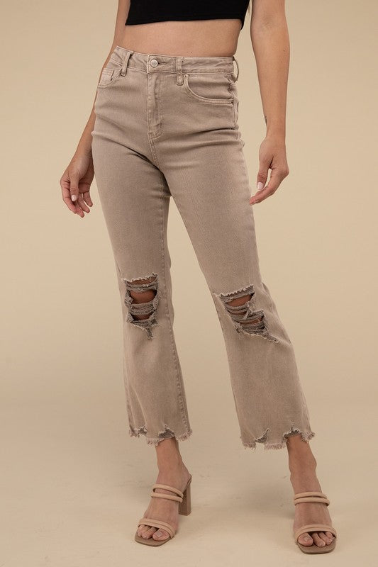 Person wearing acid washed high waist distressed straight pants and beige sandals against a neutral background.