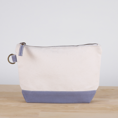 A small heavyweight canvas pouch with a black bottom, featuring a sturdy metal zipper and side loop detail, from the All In Zip Top Pouch collection.
