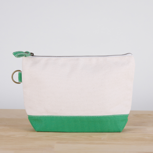 A small heavyweight canvas pouch with a black bottom, featuring a sturdy metal zipper and side loop detail, from the All In Zip Top Pouch collection.