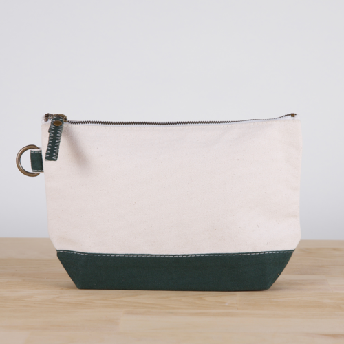 A small heavyweight canvas pouch with a black bottom, featuring a sturdy metal zipper and side loop detail, from the All In Zip Top Pouch collection.