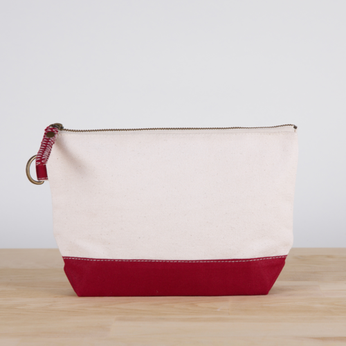 A small heavyweight canvas pouch with a black bottom, featuring a sturdy metal zipper and side loop detail, from the All In Zip Top Pouch collection.