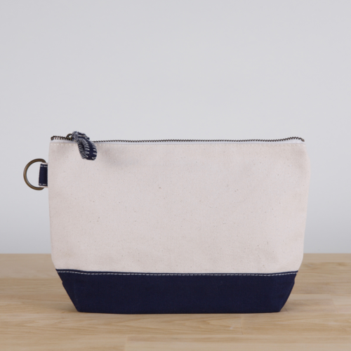 A small heavyweight canvas pouch with a black bottom, featuring a sturdy metal zipper and side loop detail, from the All In Zip Top Pouch collection.
