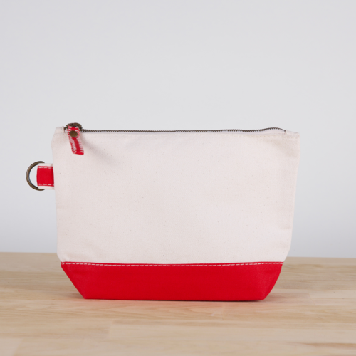 A small heavyweight canvas pouch with a black bottom, featuring a sturdy metal zipper and side loop detail, from the All In Zip Top Pouch collection.