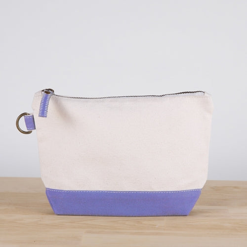 A small heavyweight canvas pouch with a black bottom, featuring a sturdy metal zipper and side loop detail, from the All In Zip Top Pouch collection.
