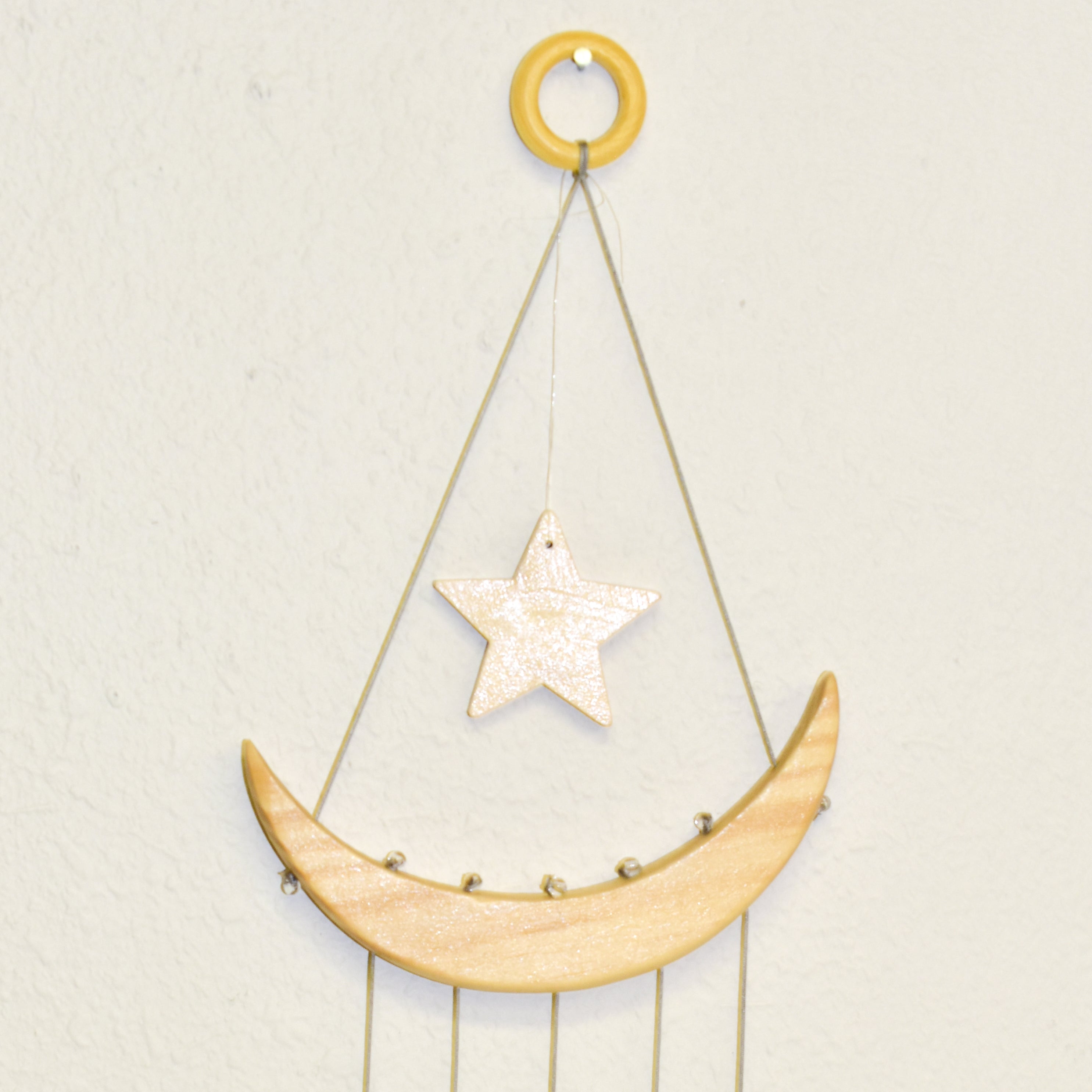 The NEW Star & Crescent Moon Agate Wind Chime features a mesmerizing wood crescent moon embellished with vibrant stones that mimic natural agate slices, all elegantly accentuated by two wooden triangular shelves.