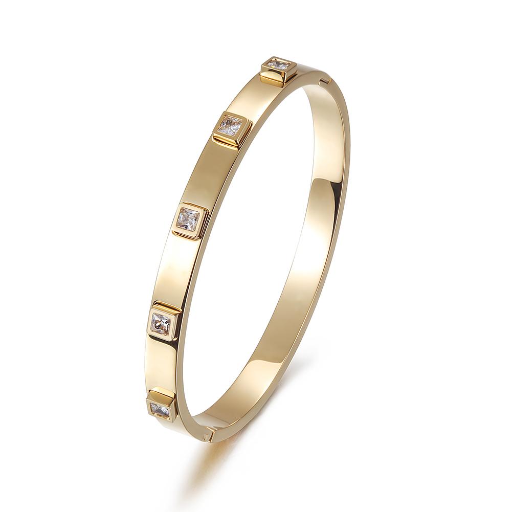 The Metal Stone Hinged Bangle is a sleek 14K gold PVD plated stainless steel bracelet, featuring square diamond accents evenly spaced along its hypoallergenic band.
