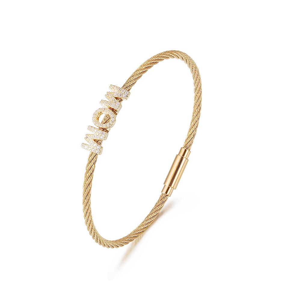 The "Mom" Pavé Bracelet displays "MOM" with diamond-studded letters on a cable chain, crafted from hypoallergenic 14K gold PVD plated material for enduring beauty and comfort.