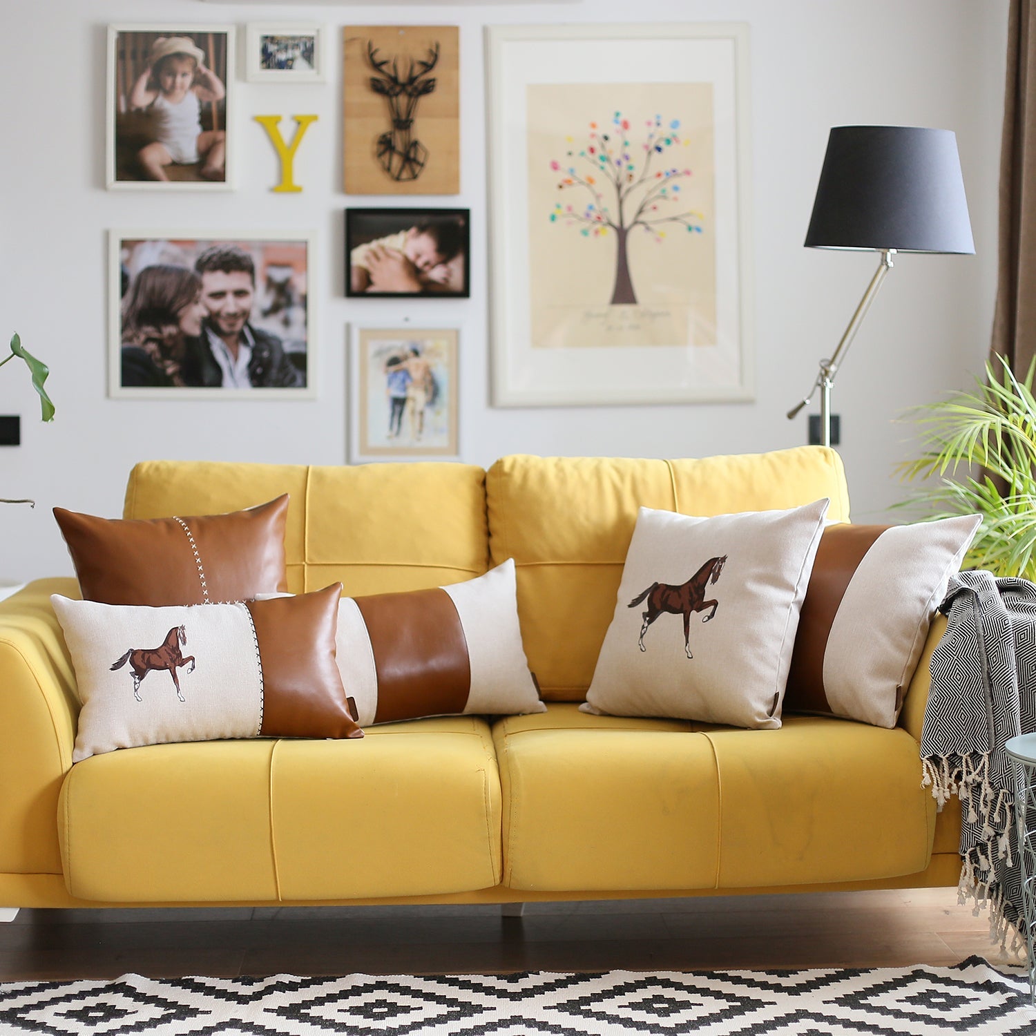 Placed on a brown sofa is the Boho Embroidered Horse Throw Pillow, a solid beige and brown square cushion measuring 18" x 18", featuring an illustration of a horse and made with recycled polyester filling, ensuring OEKO-TEX certification.