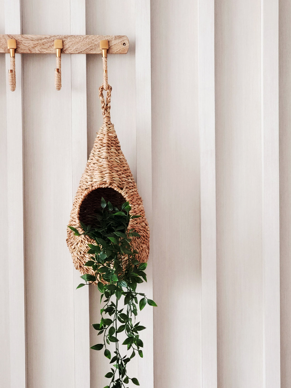 The teardrop-shaped Savar Pot Planter, handwoven from seagrass by Fair Trade artisans, showcases an open circular entrance against a plain white background.