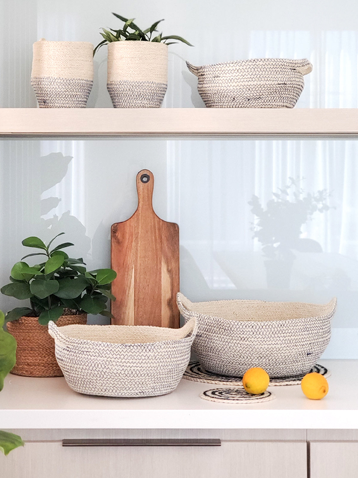 Three Amari Fruit Bowls in black are elegantly arranged on a white background. Handcrafted by Fair Trade artisans, these sustainably made pieces add an eco-friendly touch to any space.