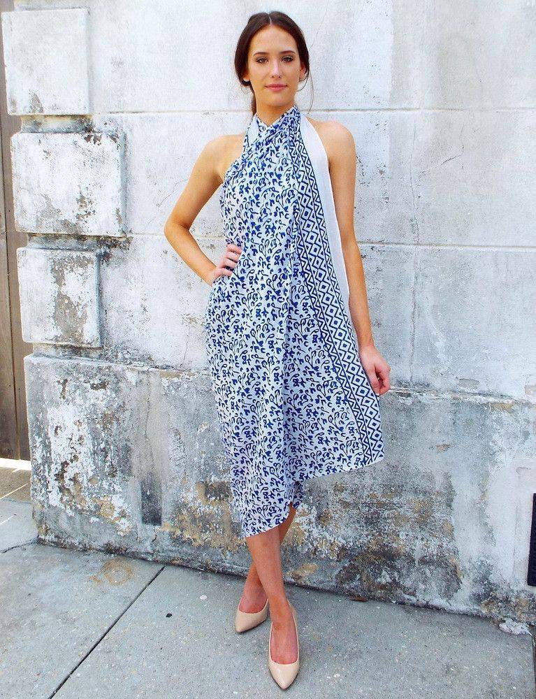 Person wearing an Abstract Blue Sarong and beige heels, standing against a textured white wall.