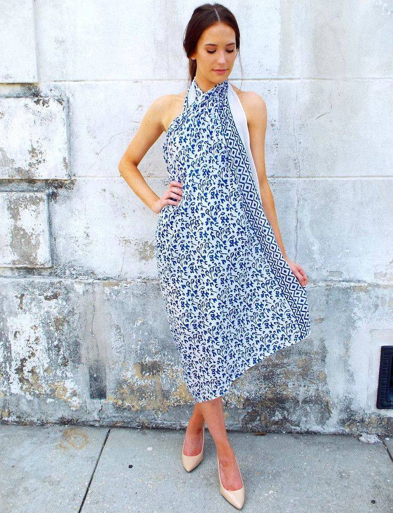 Person wearing an Abstract Blue Sarong and beige heels, standing against a textured white wall.