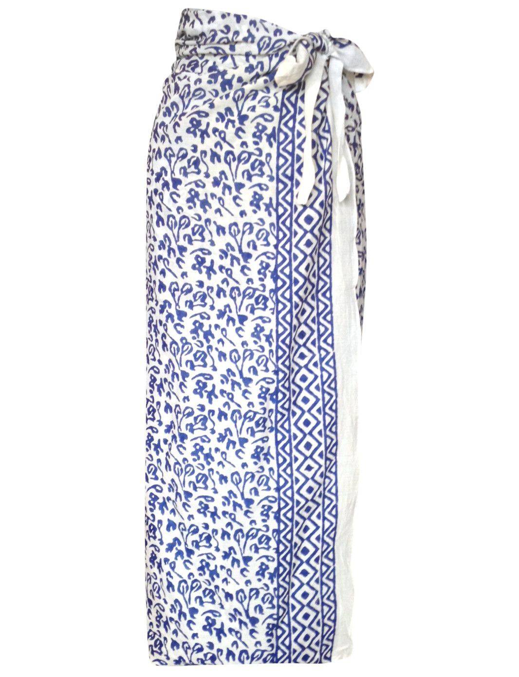 Person wearing an Abstract Blue Sarong and beige heels, standing against a textured white wall.
