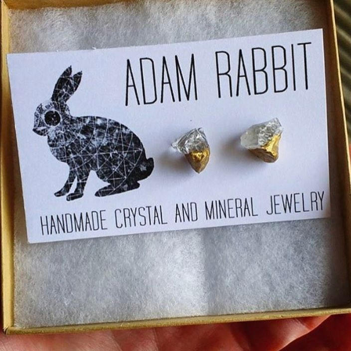 The Gold & Raw Quartz Chunk Earrings, showcasing their raw beauty with gold accents, stand out on a gray backdrop, making a bold statement in the realm of unique jewelry.