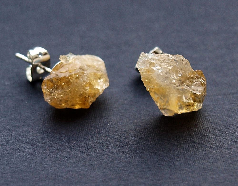A pair of Raw Citrine Chunk Earrings, also known as Geo Earrings or Rock Stud Earrings, are elegantly showcased on a dark background, highlighting the allure of unique crystal jewelry.