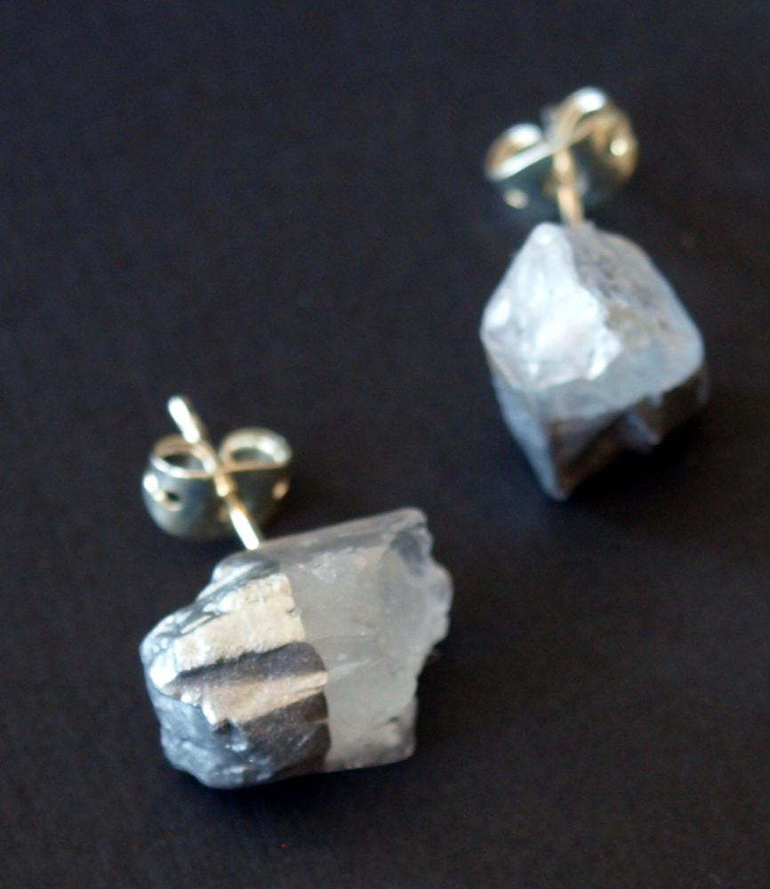 A pair of Silver & Raw Quartz Chunk Earrings with metal bases sit gracefully on a dark surface, embodying spiritual growth. Expertly gift wrapped, they make an ideal present for any occasion.