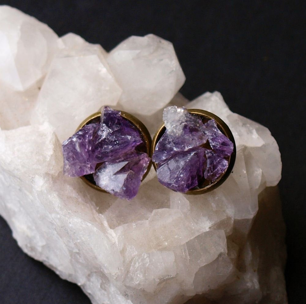 Raw amethyst cluster stud earrings rest elegantly on a textured black surface, offering the perfect touch of luxury for any gift-giving occasion.