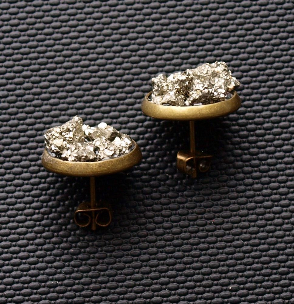 Two Pyrite Cluster Stud Earrings featuring raw pyrite with textured, metallic gold-colored surfaces that resemble clustered nuggets or rocks, set against a dark background.