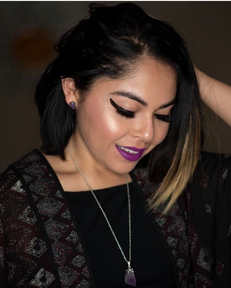 Close-up of the Raw Amethyst Earrings, featuring two raw stud amethysts with surgical steel posts, set against a dark background.
