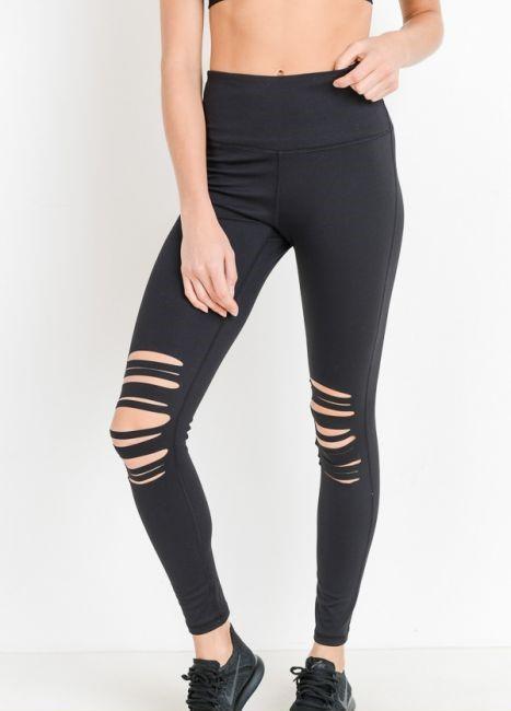 A person is wearing a black crop top and High Waist Laser Cut Ripped Knee Leggings boasting moisture-wicking properties, paired with black shoes.