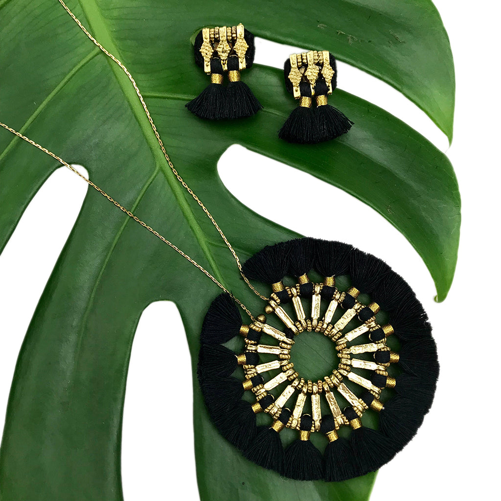 A pair of Jhumka Earrings in gold and black, showcasing detailed geometric designs with fringed ends.
