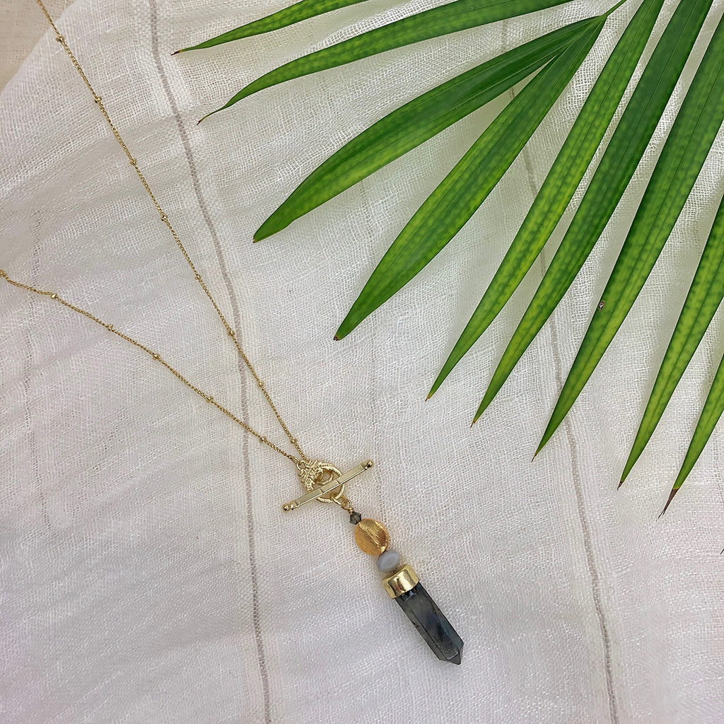 Discover the Labradorite Lariat Necklace, a gold chain featuring a toggle clasp and labradorite pendant—ideal for those who appreciate artisan jewelry.
