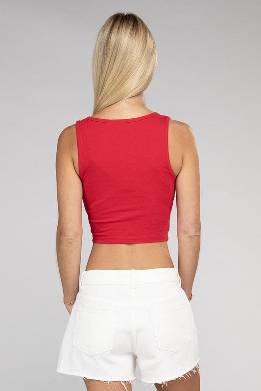 A woman with blonde hair smiling, wearing a Cotton Square Neck Cropped Cami Top and white pants, standing against a grey background.
