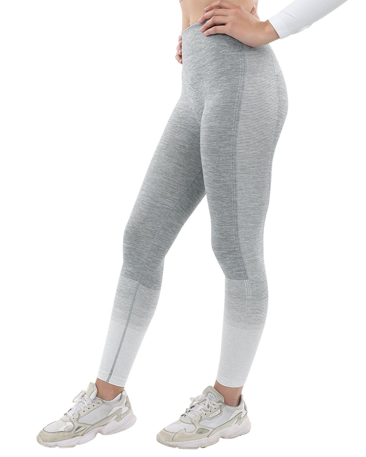 A person showcases Bocana Seamless Leggings in grey & white against a white background, paired with white sneakers.