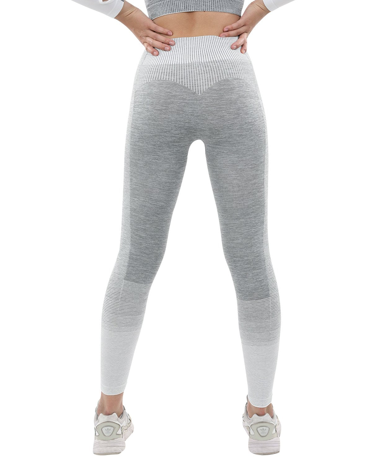 A person showcases Bocana Seamless Leggings in grey & white against a white background, paired with white sneakers.