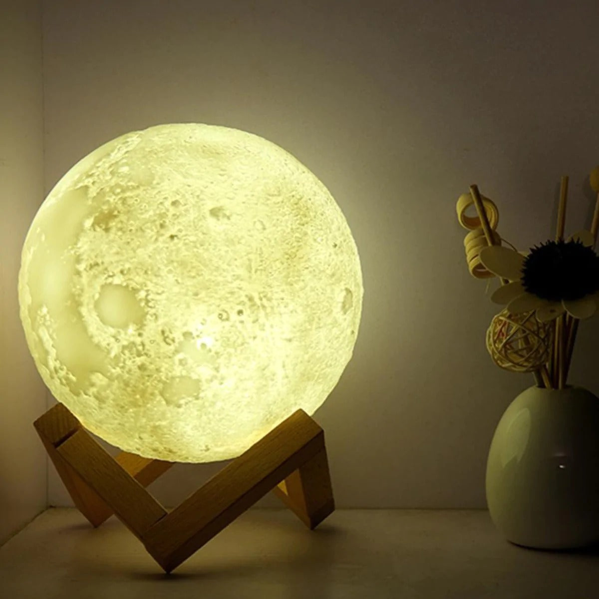 A Glowing Moon Lamp with stand with different colored balls and a remote control.