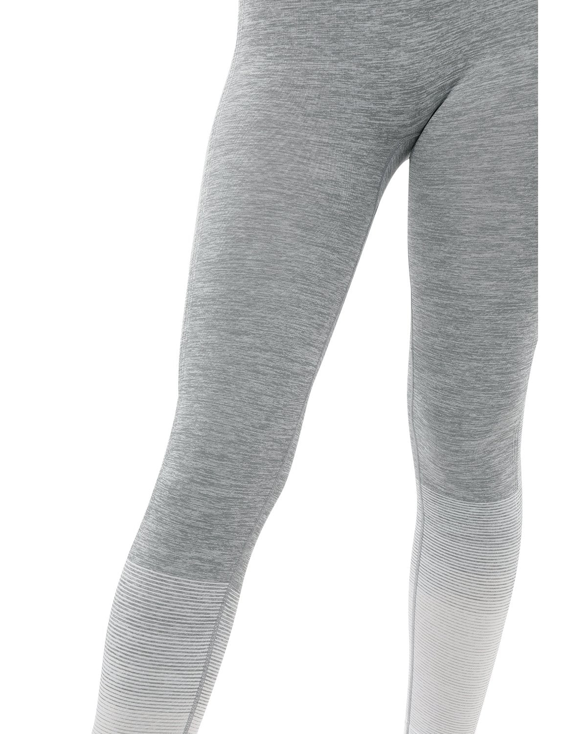 A person showcases Bocana Seamless Leggings in grey & white against a white background, paired with white sneakers.