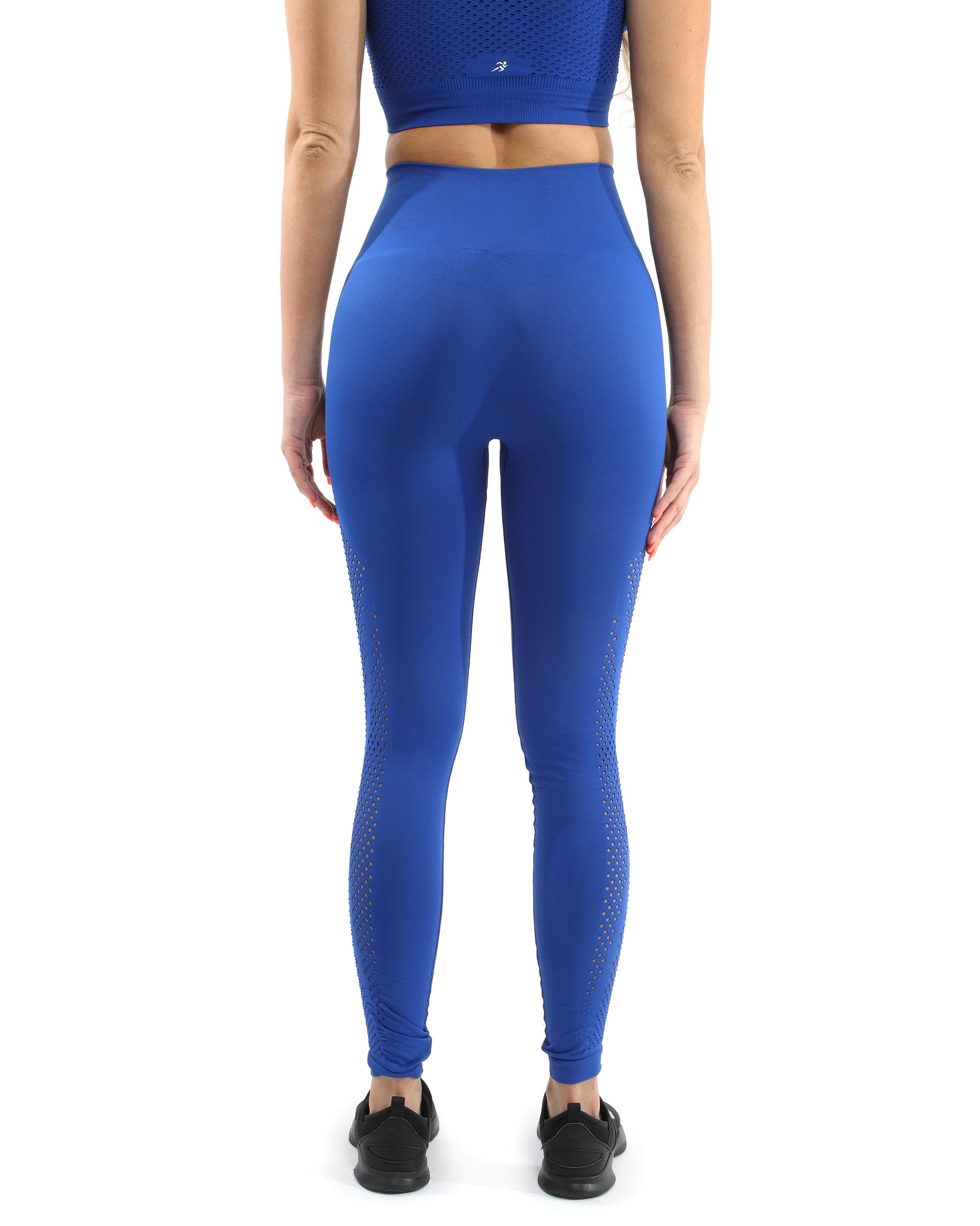 A person is wearing blue Milano Seamless Leggings, which are on sale for 50% off, and black shoes, standing with hands out of frame.