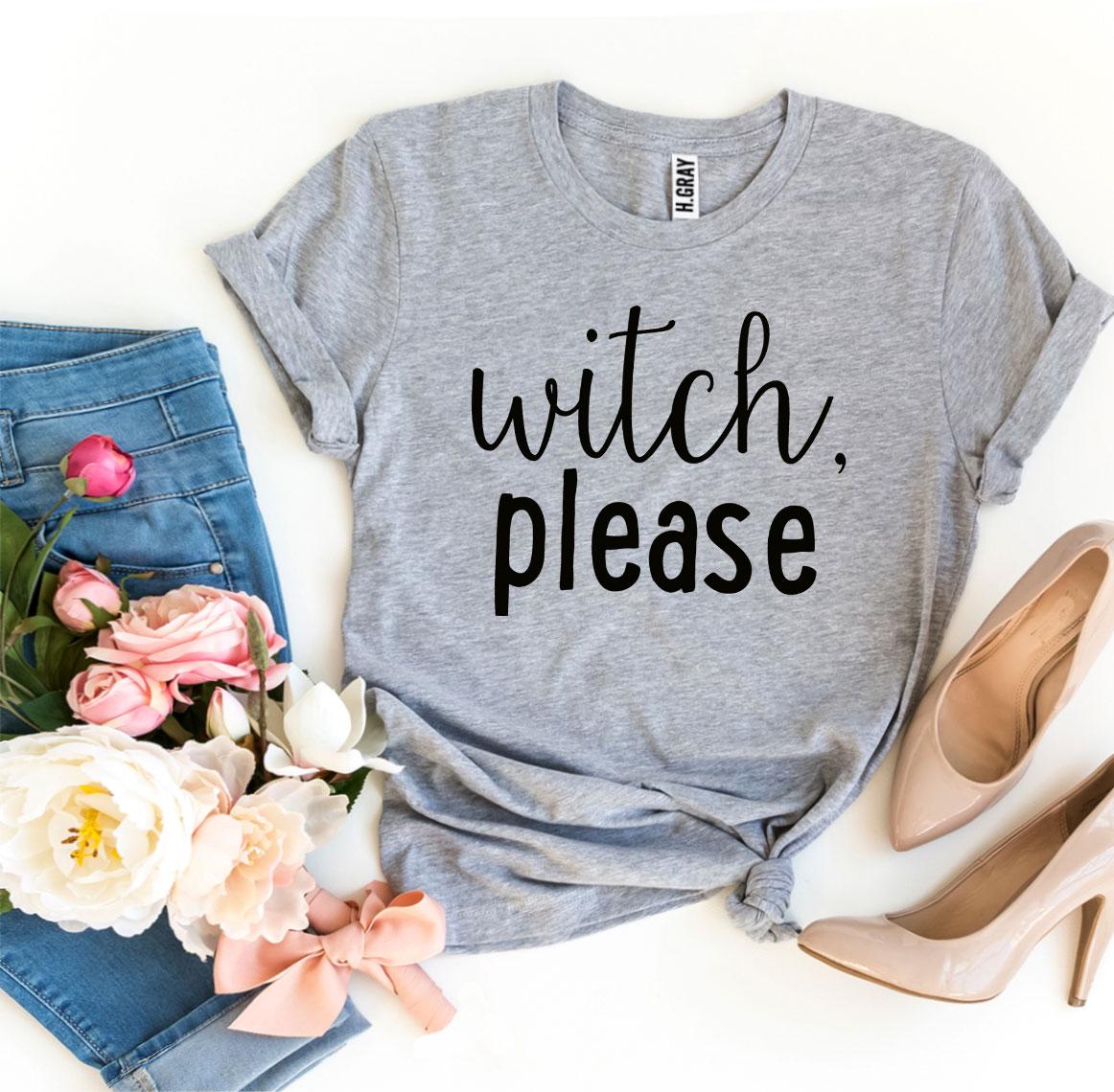 A Witch Please T-shirt in gray, celebrated for its soft texture and comfortable retail fit, is beautifully laid out next to a pair of blue jeans, beige high heels, and a bouquet of flowers.