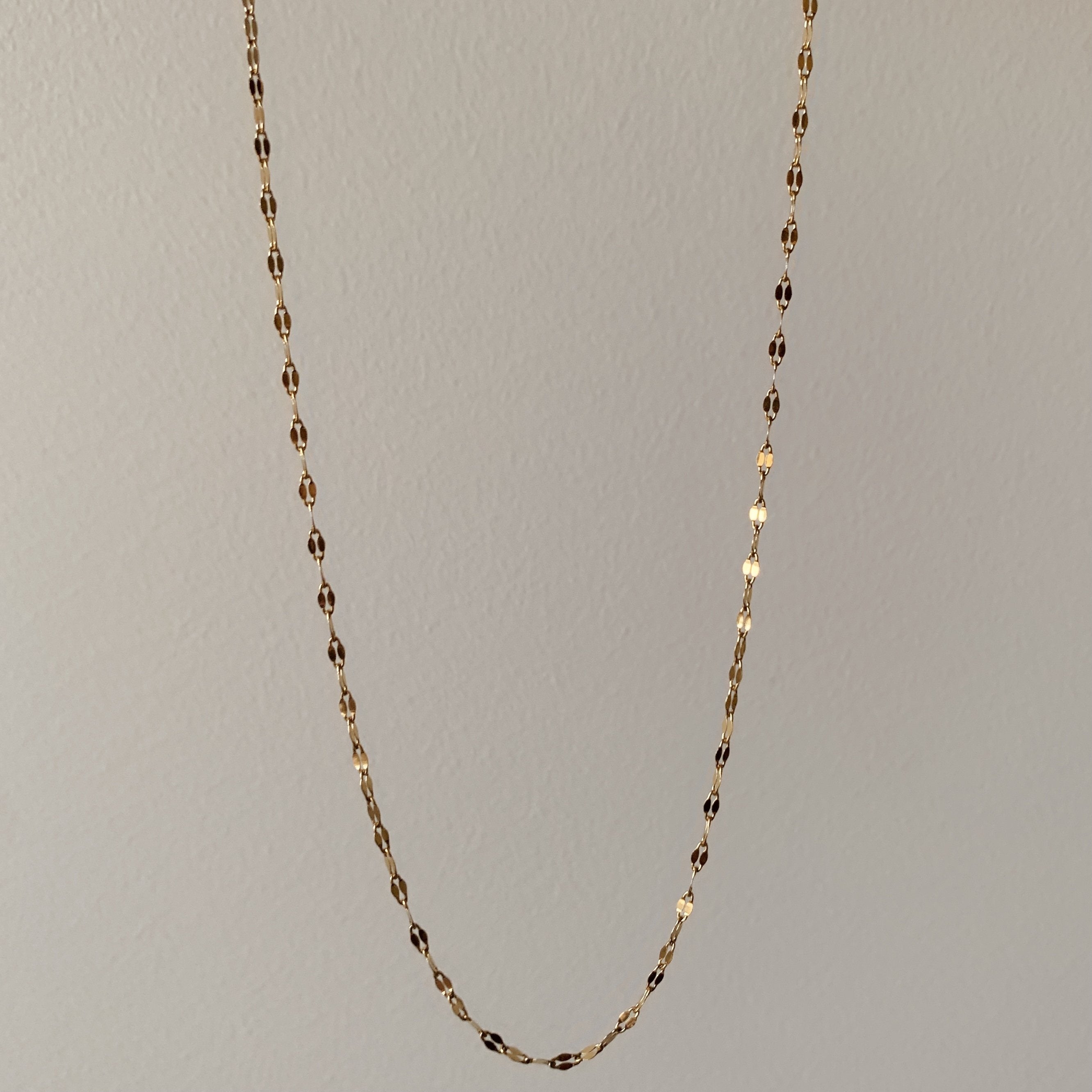 The Diana Choker Necklace, with its 18K gold plating, is elegantly displayed on a light gray backdrop, exuding subtle sophistication.