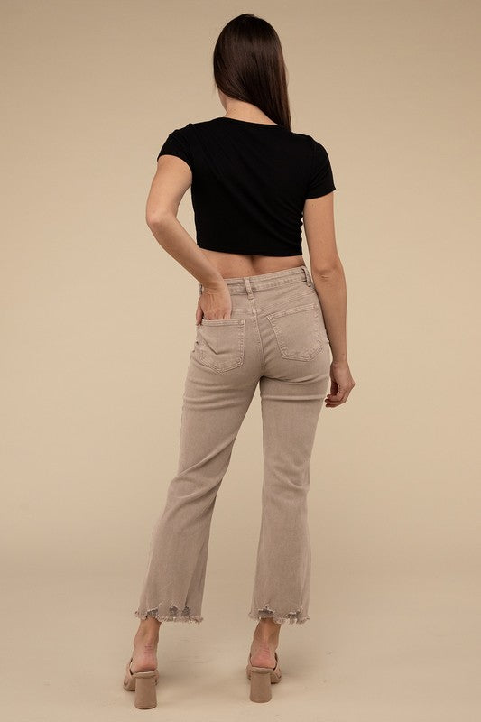 Person wearing acid washed high waist distressed straight pants and beige sandals against a neutral background.
