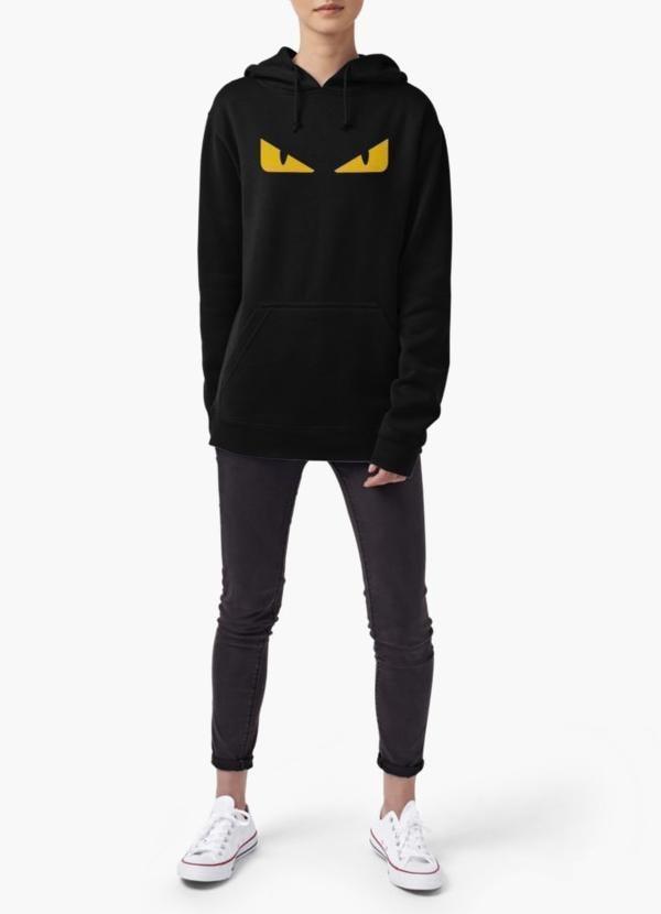 A person wearing a custom-fitted Fendi monster eye women black hoodie, along with black jeans and white sneakers, stands against a plain background.