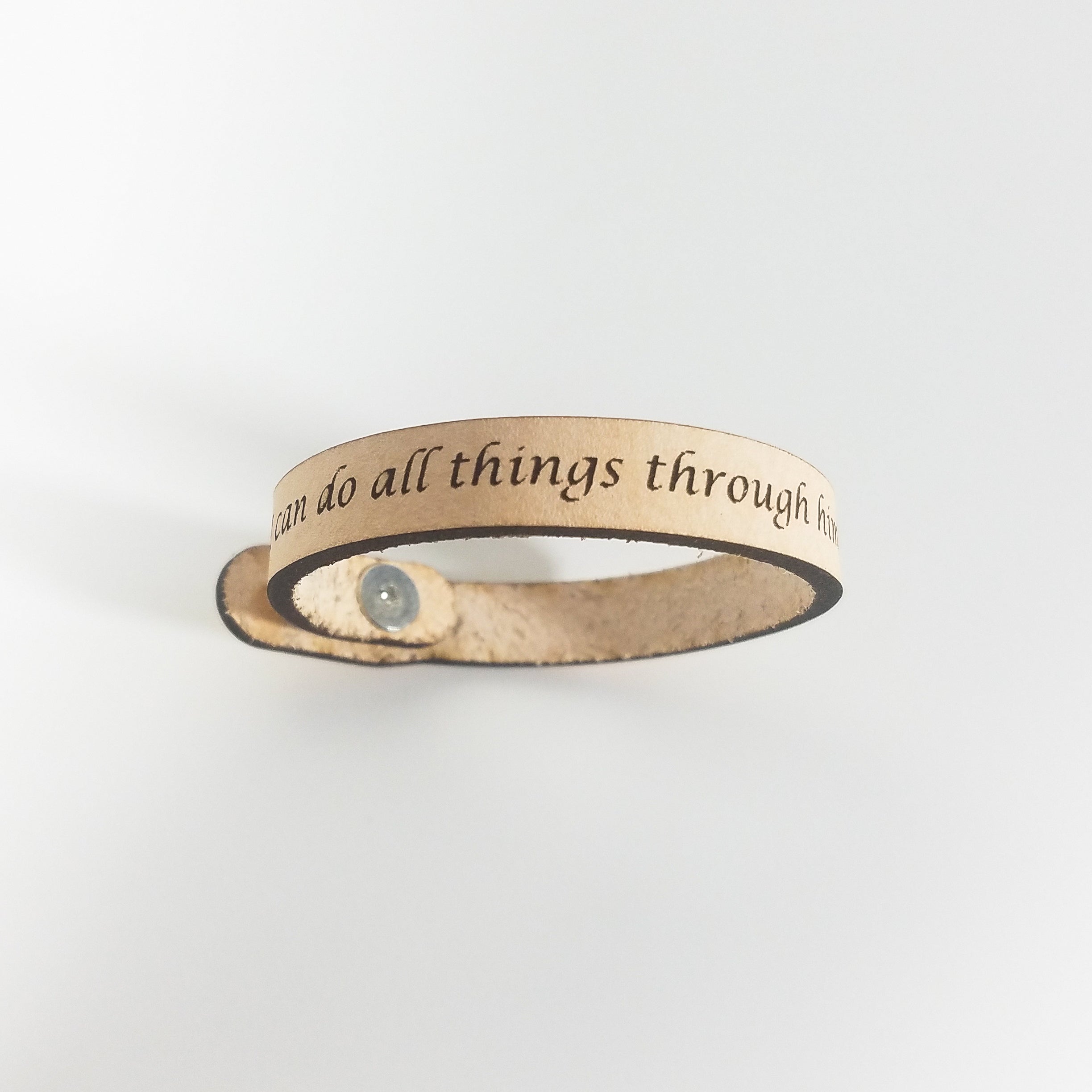The Spiritual Quote Bracelet, made of genuine leather and featuring an adjustable button closure, skillfully blends style with motivation by showcasing the inspirational message: "I can do all things through him who strengthens me.