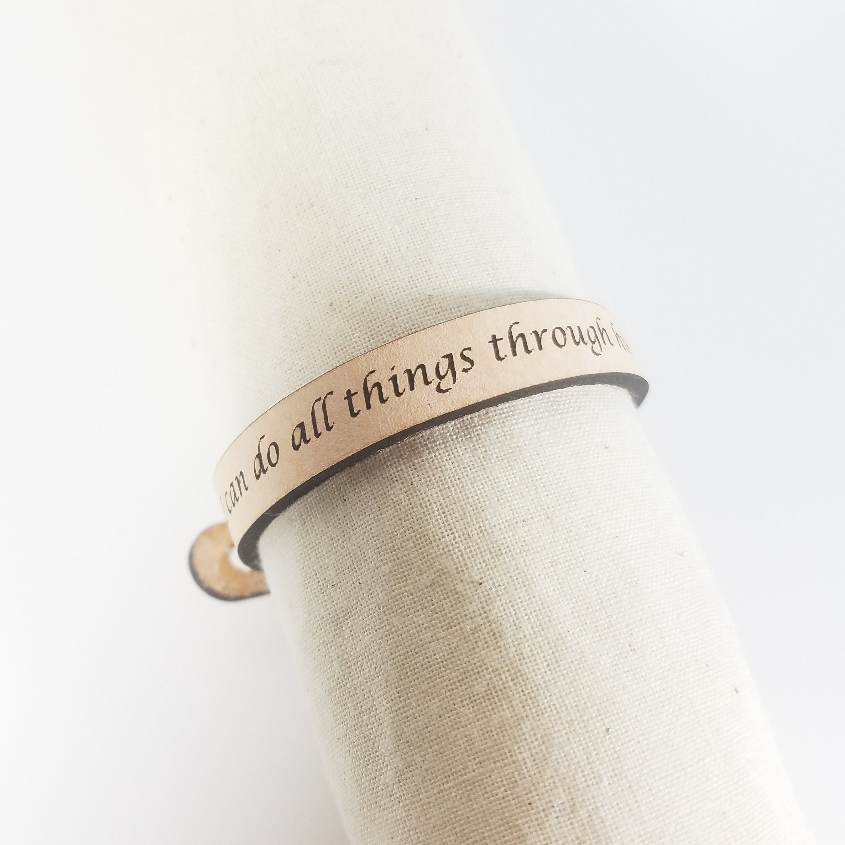 The Spiritual Quote Bracelet, made of genuine leather and featuring an adjustable button closure, skillfully blends style with motivation by showcasing the inspirational message: "I can do all things through him who strengthens me.