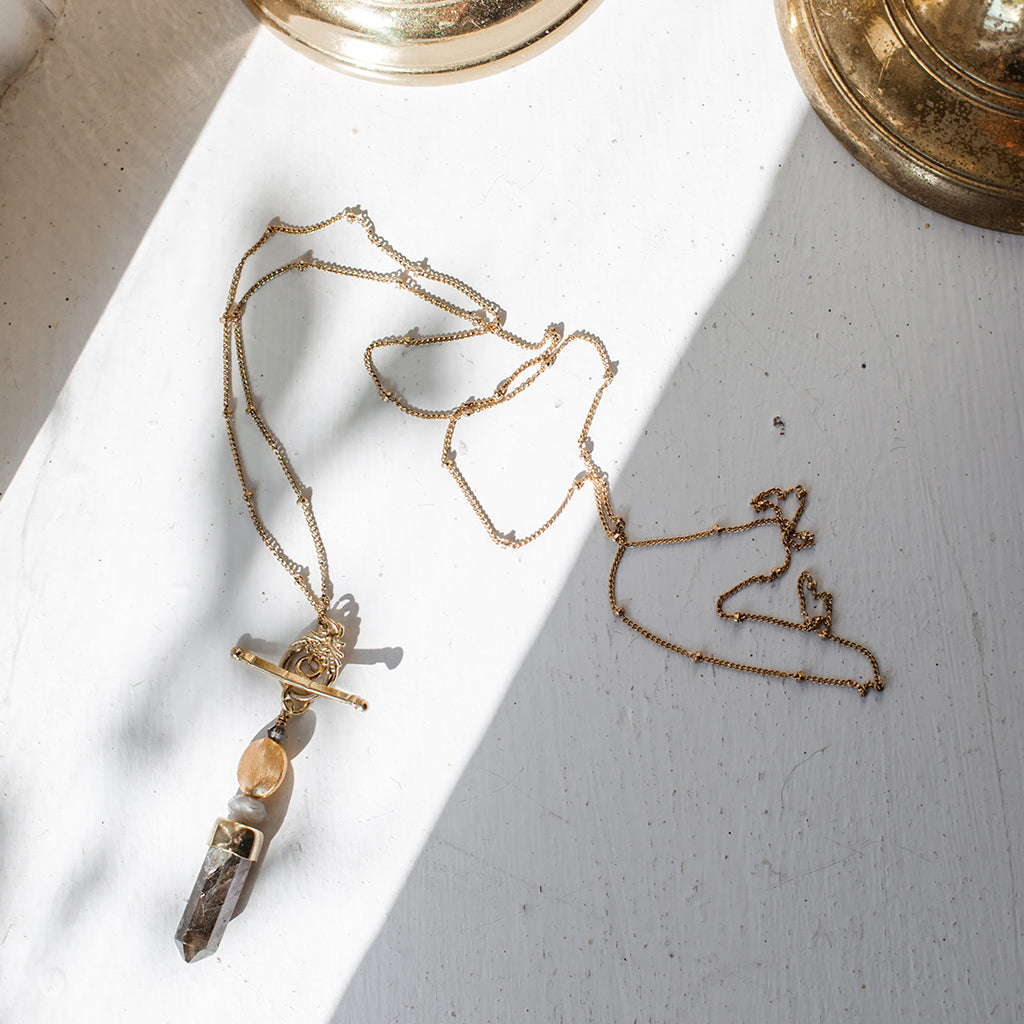 Discover the Labradorite Lariat Necklace, a gold chain featuring a toggle clasp and labradorite pendant—ideal for those who appreciate artisan jewelry.